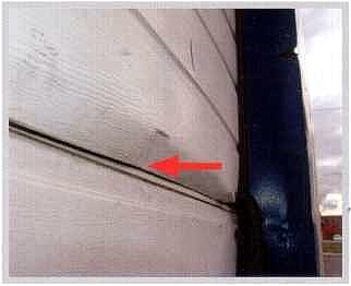 Деформация панелей на стыке, полученная при силовом открывании ворот, с обледенением в зоне защиты от защемления пальцев. Межпанельный уплотнитель нижней панели выдавлен верхней сэндвич-панелью